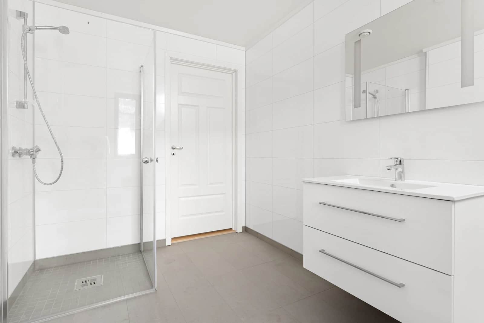 Bright modern bathroom with clean tiled surfaces and glass shower