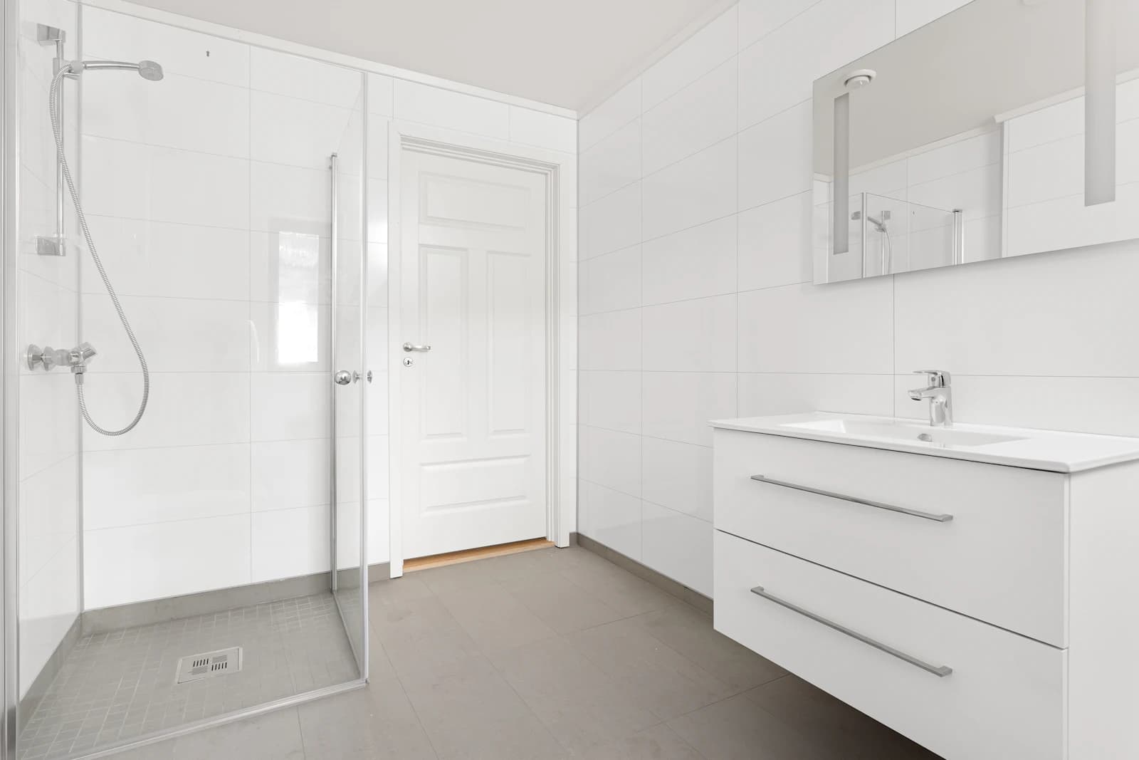 Bright modern bathroom with clean tiled surfaces and glass shower